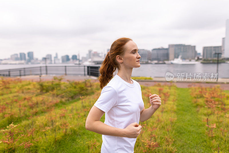 Young woman jogging in bayside public park